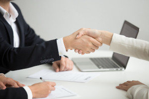 Employment handshake concept, female hr and successful woman candidate shaking hands getting hired ready to sign job contract concept, employer congratulating welcoming new worker, close up view