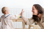 Mother and baby daughter giving high fives